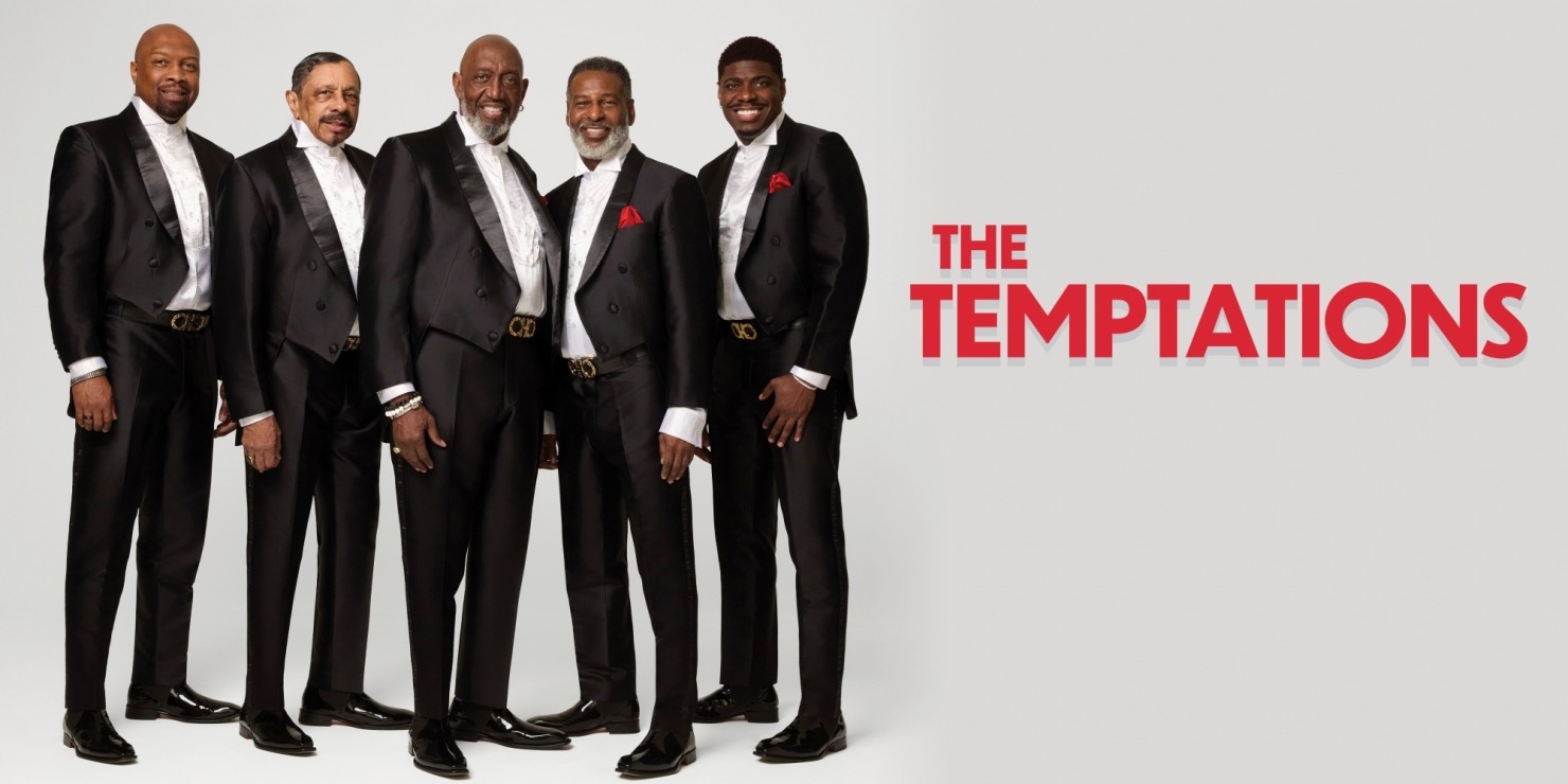 five men in tuxedos pose together smiling
