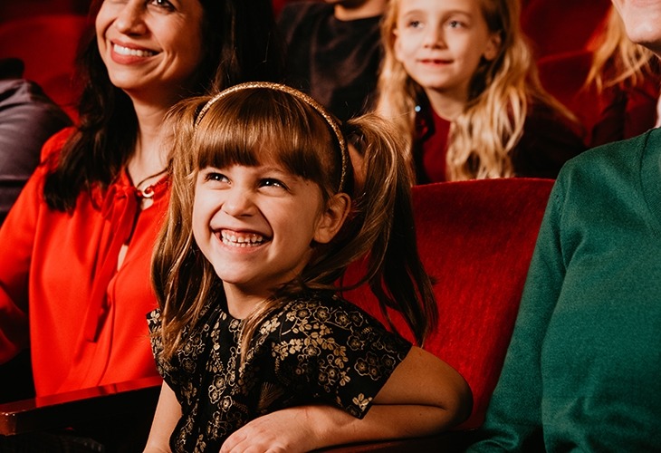 Image of a smiling little girl in the audience enjoying a show at the Lied Center