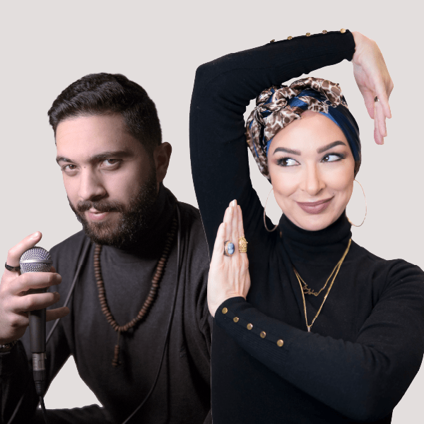Picture of a woman and a man both it black turtle necks. Women has one arm above her head and one positioned up across her chest. The man is holding a microphone.