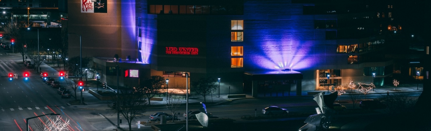 Image of the Lied Center building at night lit up in purple