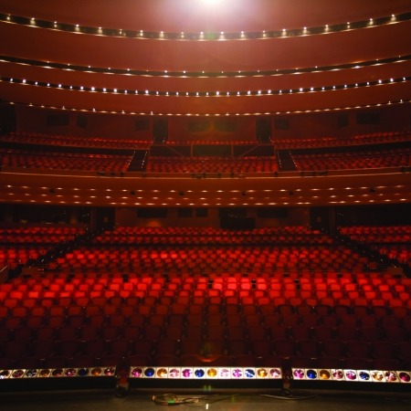 Image of the Lied Center auditorium taken from the stage looking out into an empty hall full of red, plush seats.